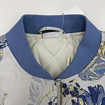 Close-up of a stylish women's bomber jacket with intricate embroidery and a blue collar, perfect for fashion-forward outfits.