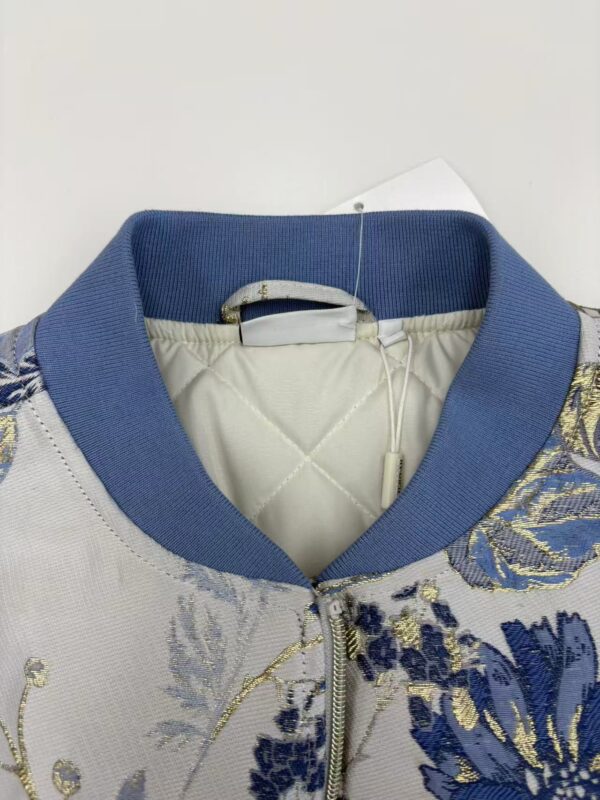 Close-up of a stylish women's bomber jacket with intricate embroidery and a blue collar, perfect for fashion-forward outfits.