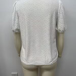 White eyelet blouse with puff sleeves and intricate embroidery, perfect for casual or semi-formal occasions.