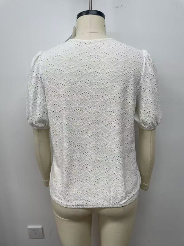 White eyelet blouse with puff sleeves and intricate embroidery, perfect for casual or semi-formal occasions.