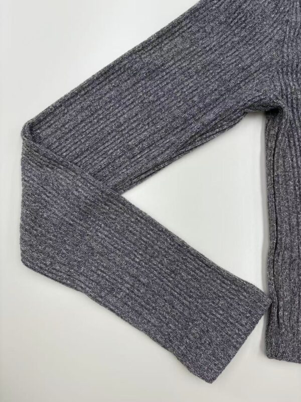 Close-up of a grey knitted sweater with ribbed texture, perfect for casual or office wear, showcasing high-quality fabric and craftsmanship.