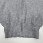 Close-up of a gray zip-up hoodie made of soft fabric, featuring a front zipper and ribbed cuffs, ideal for casual wear and comfortable style.