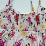 Beautiful floral summer dress with pink, purple, and yellow flowers on a light background, featuring adjustable straps and smocked bodice for a comfortable fit.