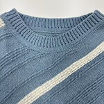 Close-up of a blue knitted sweater featuring a white stripe, showcasing detailed stitching and texture, ideal for fashion and clothing SEO.