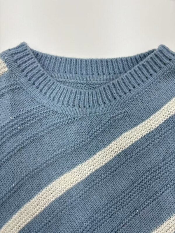 Close-up of a blue knitted sweater featuring a white stripe, showcasing detailed stitching and texture, ideal for fashion and clothing SEO.