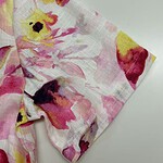 Close-up of floral fabric with pink, yellow, and black accents, suitable for clothing or accessories.
