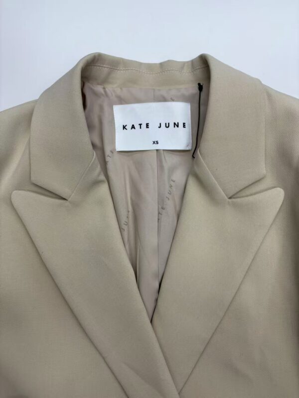 Elegant beige blazer by Kate June, XS size, perfect for professional and casual wear, featuring a classic lapel collar and tailored fit.