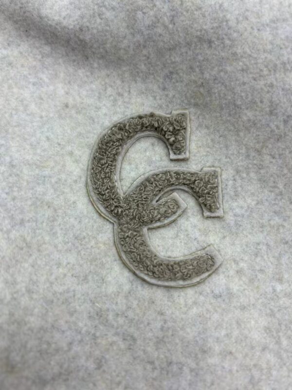 Close-up of a silver Euro coin designed as a fashion accessory, showcasing intricate detailing and craftsmanship.