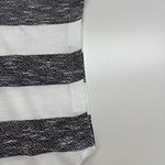 Close-up of a fabric with horizontal black and white stripes, showcasing texture and pattern suitable for fashion design.