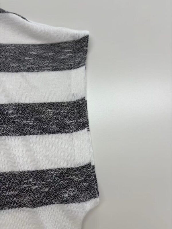 Close-up of a fabric with horizontal black and white stripes, showcasing texture and pattern suitable for fashion design.