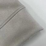 Close-up of beige fabric with smooth texture and fine stitching, ideal for fashion and apparel design.