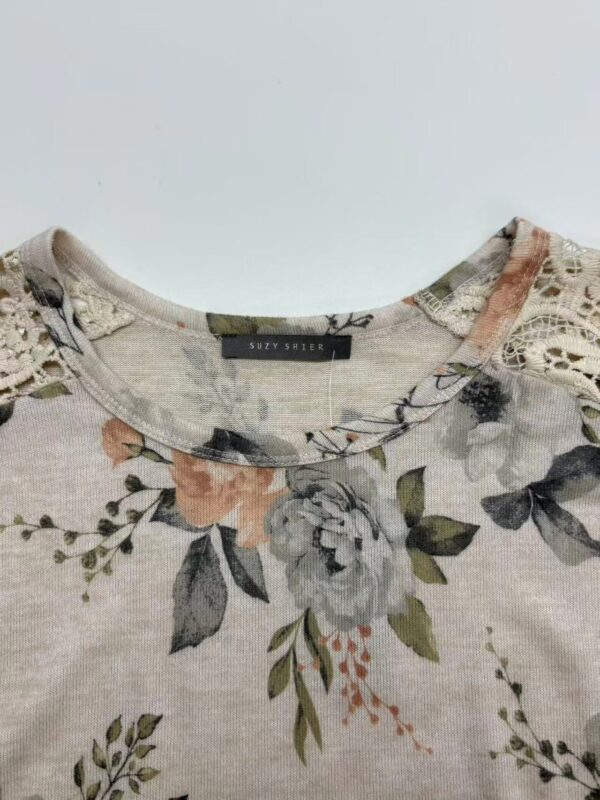 Close-up of a women's top with floral print, lace details on shoulders, and a round neckline, perfect for casual or semi-formal wear.