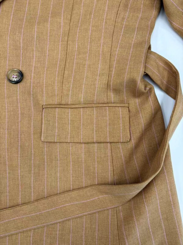 Close-up of a men's brown pinstripe blazer with a pocket and button detail, suitable for formal or business wear.