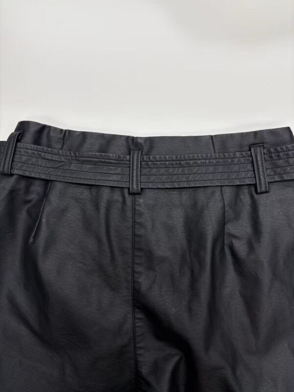 Close-up of black dress pants with belt loops, suitable for formal occasions and office wear, made from high-quality fabric.