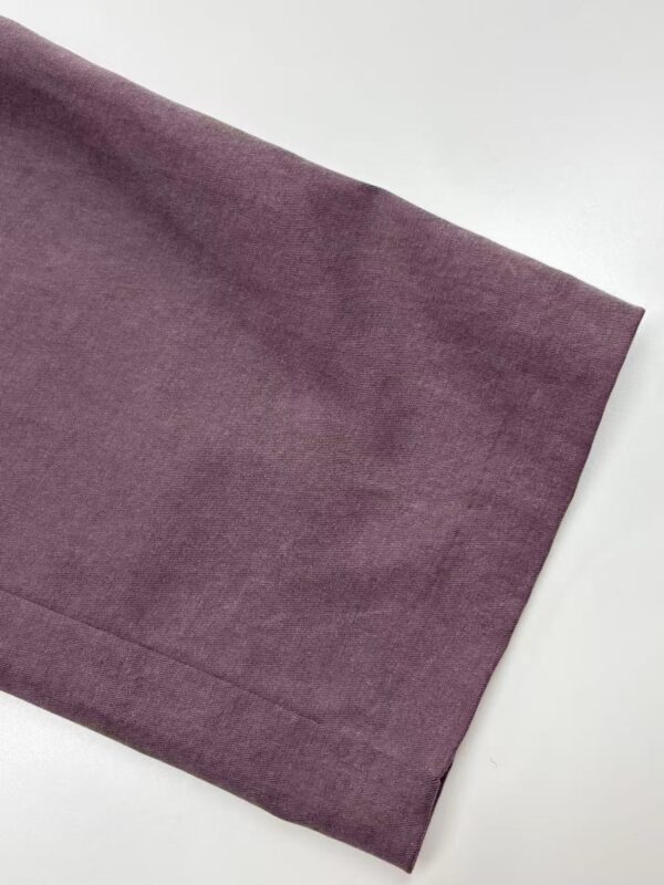 Close-up of a smooth, purple fabric with a subtle sheen, ideal for high-end fashion garments and accessories.