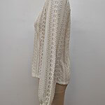 Elegant cream-colored lace long sleeve top displayed on a mannequin, showcasing intricate floral patterns and delicate craftsmanship.