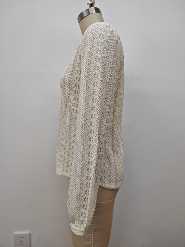 Elegant cream-colored lace long sleeve top displayed on a mannequin, showcasing intricate floral patterns and delicate craftsmanship.