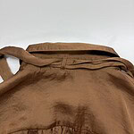 Close-up of a brown leather bag with a strap, showcasing its texture and design, suitable for fashion and accessory SEO.