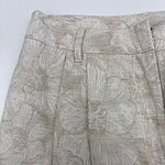 Close-up of beige floral-patterned women's trousers with belt loops and tailored fit, perfect for casual or semi-formal occasions.