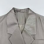 Close-up of a stylish satin blazer with a notched lapel, perfect for formal or evening wear, showcasing smooth fabric and tailored design.