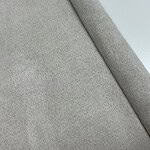 Close-up of light gray wool fabric showcasing its soft texture and fine weave, ideal for high-quality fashion and upholstery.