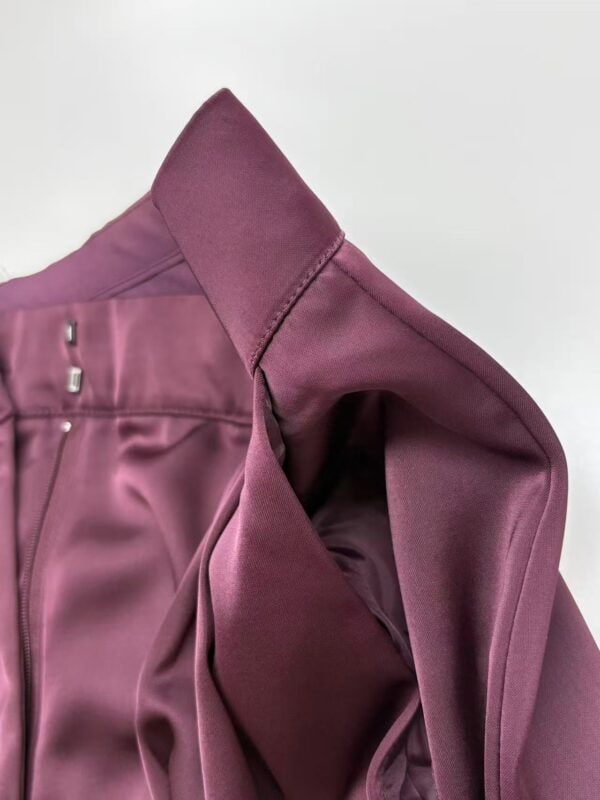 Close-up of a stylish burgundy blazer with detailed stitching and smooth fabric, perfect for professional or formal occasions.