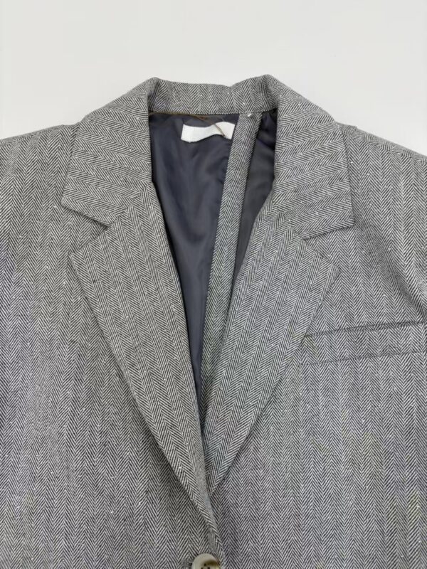 Elegant men's grey herringbone suit jacket with notch lapel, ideal for formal occasions and professional settings.
