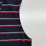 Close-up of a navy blue knit sweater with red, white, and blue horizontal stripes, showcasing a casual and stylish design.