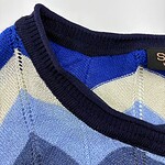 Close-up of a men's argyle sweater featuring shades of blue, cream, and navy with a V-neck design, perfect for casual or semi-formal wear.