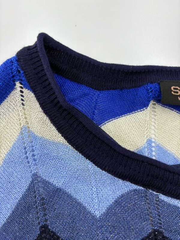 Close-up of a men's argyle sweater featuring shades of blue, cream, and navy with a V-neck design, perfect for casual or semi-formal wear.