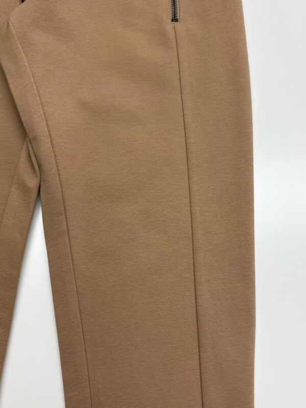 Close-up of stylish brown men's pants with zipper detail, made from high-quality fabric, perfect for casual or semi-formal wear.