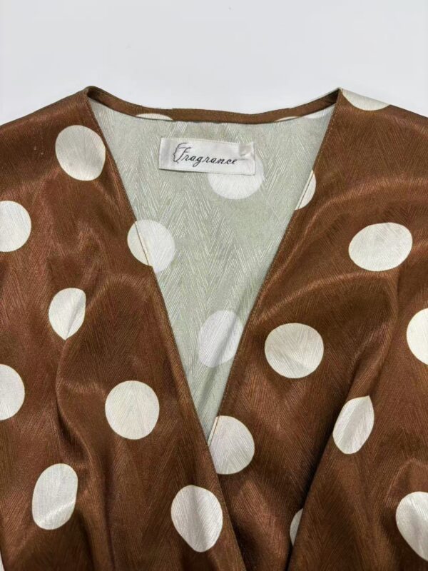 Elegant brown satin dress with large white polka dots, V-neckline, and soft fabric, perfect for stylish occasions and fashion-forward outfits.