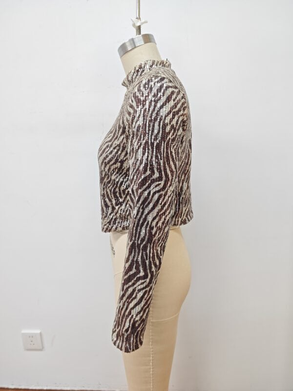 Close-up of a women's animal print knit sweater displayed on a mannequin, showcasing the detailed pattern and cozy texture.