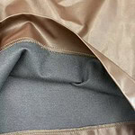 Close-up of luxurious satin and wool fabric with detailed stitching, showcasing high-quality textile materials for fashion design.