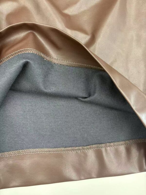 Close-up of luxurious satin and wool fabric with detailed stitching, showcasing high-quality textile materials for fashion design.