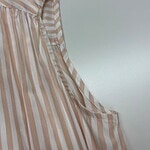 Close-up of a stylish women's blouse with beige and white vertical stripes, featuring a pleated design and a soft, flowing fabric.
