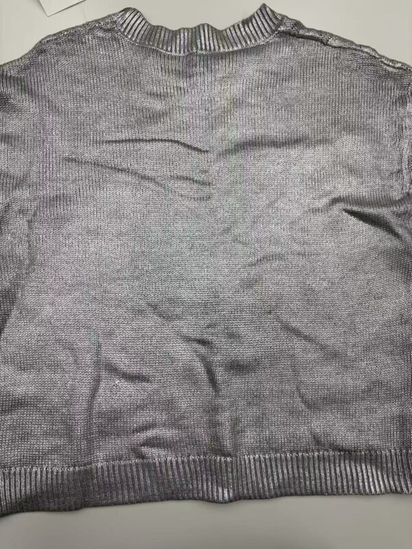 Close-up of a gray knitted sweater with ribbed collar, cuffs, and hem, made from soft yarn, suitable for casual or office wear.