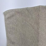 Close-up of beige knit sweater sleeve showing fine texture and stitching, ideal for fashion and clothing SEO.