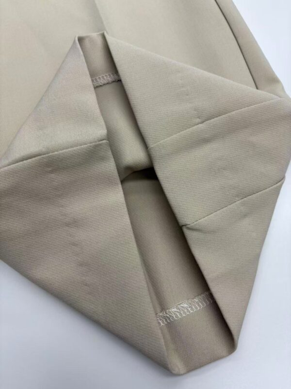 Close-up of a neatly folded beige fabric with smooth texture, ideal for fashion or home decor projects.
