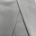 Close-up of light gray men's trousers showing fabric texture and tailored fit, ideal for business or formal wear.