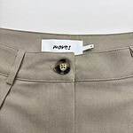 Close-up of beige trousers showing button closure and fabric texture, ideal for casual or professional wear.