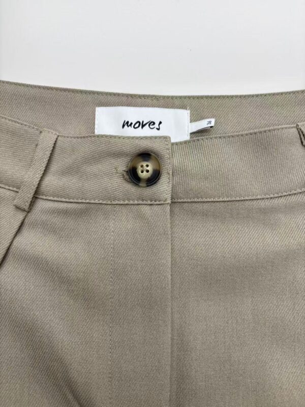 Close-up of beige trousers showing button closure and fabric texture, ideal for casual or professional wear.