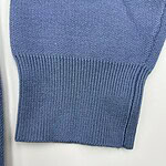 Close-up of a blue knitted sweater sleeve showing fine texture and ribbed cuff, ideal for casual or stylish winter wear.