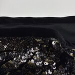 Close-up of a fabric featuring intricate embroidery and shiny sequins, suitable for stylish clothing or accessories.