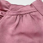 Close-up of a pink casual skirt with pleats and stitching details, suitable for everyday wear and fashion styling.