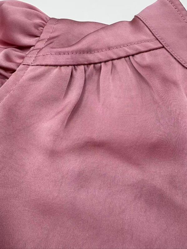 Close-up of a pink casual skirt with pleats and stitching details, suitable for everyday wear and fashion styling.