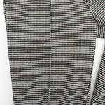 Close-up of a women's dress with a classic houndstooth pattern in black, white, and red, showcasing elegant and timeless fashion style.