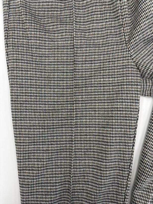 Close-up of a women's dress with a classic houndstooth pattern in black, white, and red, showcasing elegant and timeless fashion style.