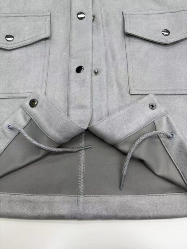 Close-up of grey cargo pants featuring multiple pockets, button details, and drawstring waist for a modern, casual look.