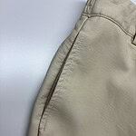 Close-up of beige casual men's pants showing fabric texture and stitching details, suitable for everyday wear and fashion.
